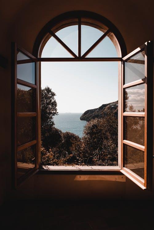 A picture of an open wooden framed glass window